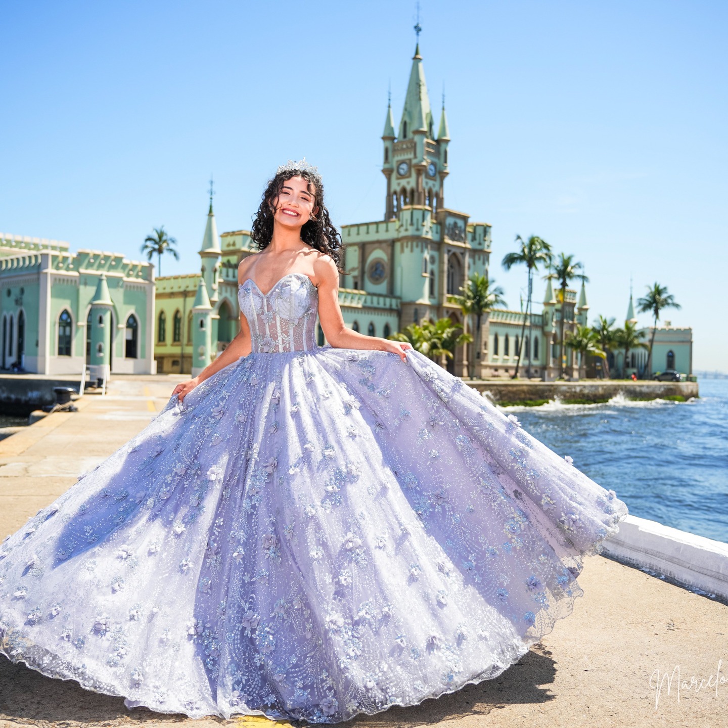 Debutante em vestido lilás com aplicações florais em frente à Ilha Fiscal, no Rio de Janeiro