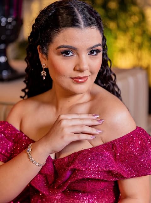 Retrato de debutante em vestido rosa pink, com a mão próxima ao rosto